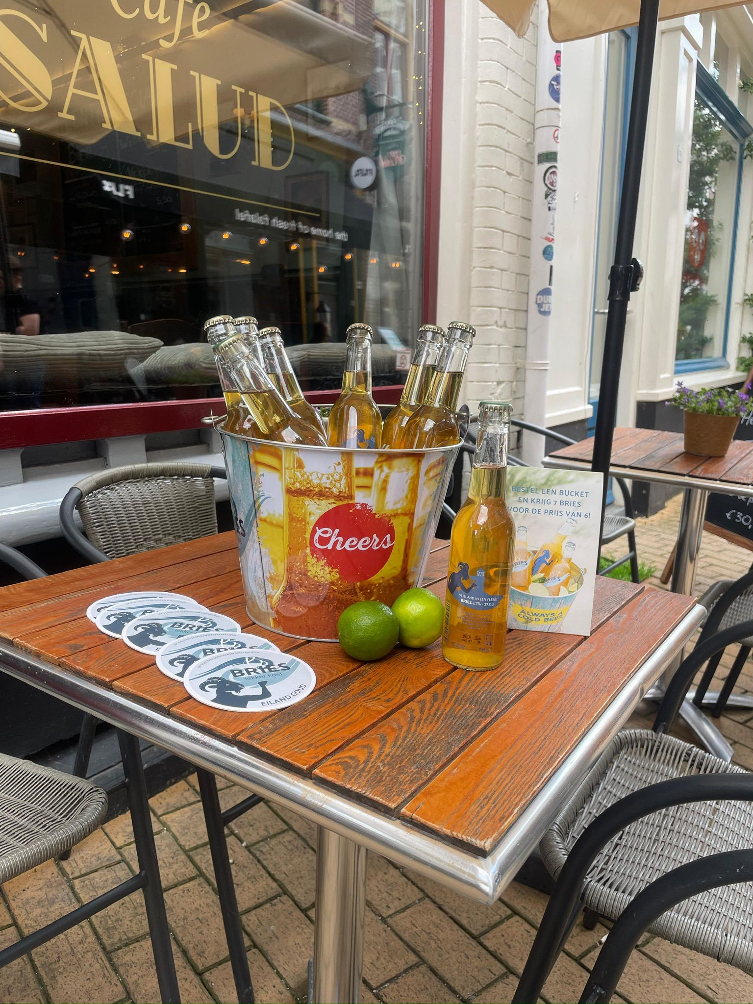 Terrastafel met koud bier en Cafe Salud-viltjes tijdens een borrel in Groningen